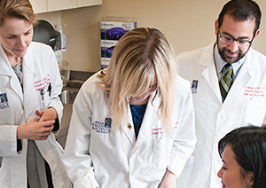 A team of OHSU doctors working collaboratively seeing a patient.