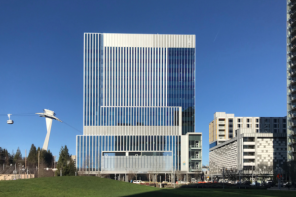 Modern building on a clear day with the tram in the background.