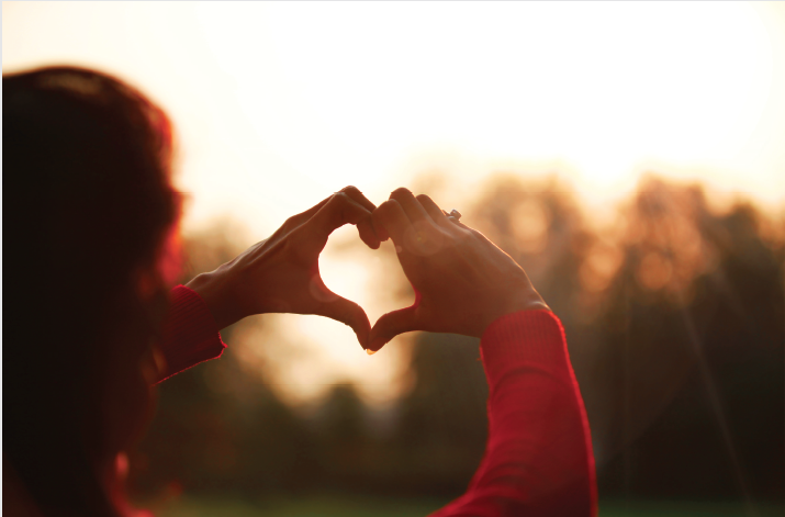 Woman holding her hand in the shape of a heart