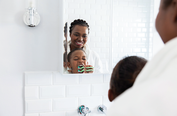 Woman and son brush teeth