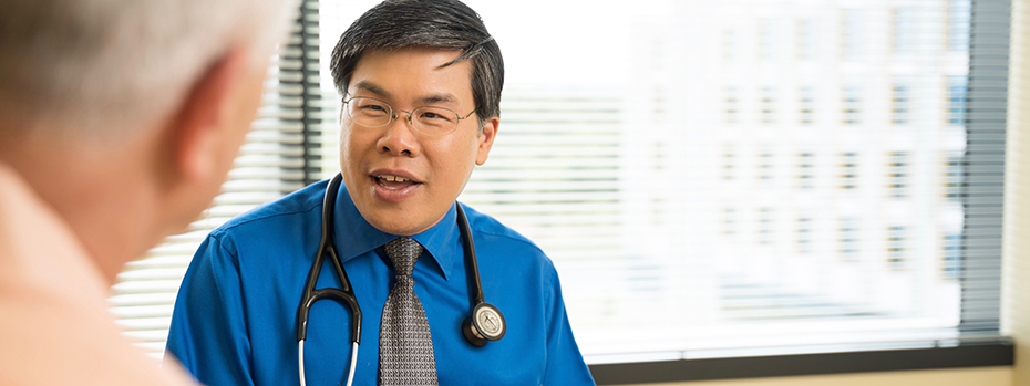 A doctor speaking with one of his patients in front of a window at OHSU.
