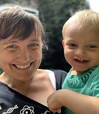 Dr. Sarah Green holding a child smiling.