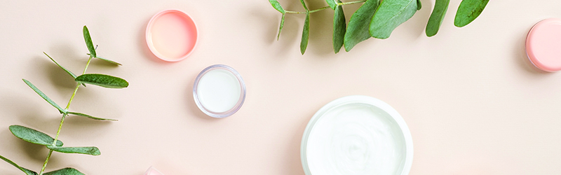 A table with an assortment of lotions and plants on it