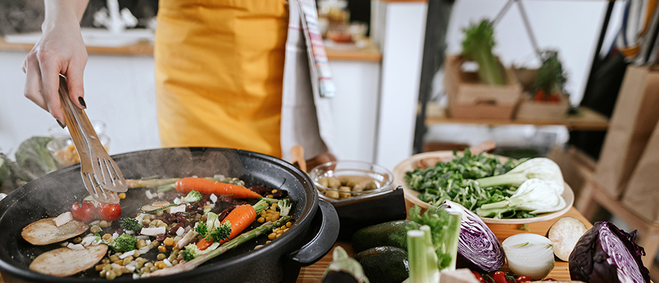 Close up of veggies and grains cooking in pan on stove