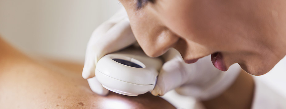 Stock photo of a clinician examining a patient's skin