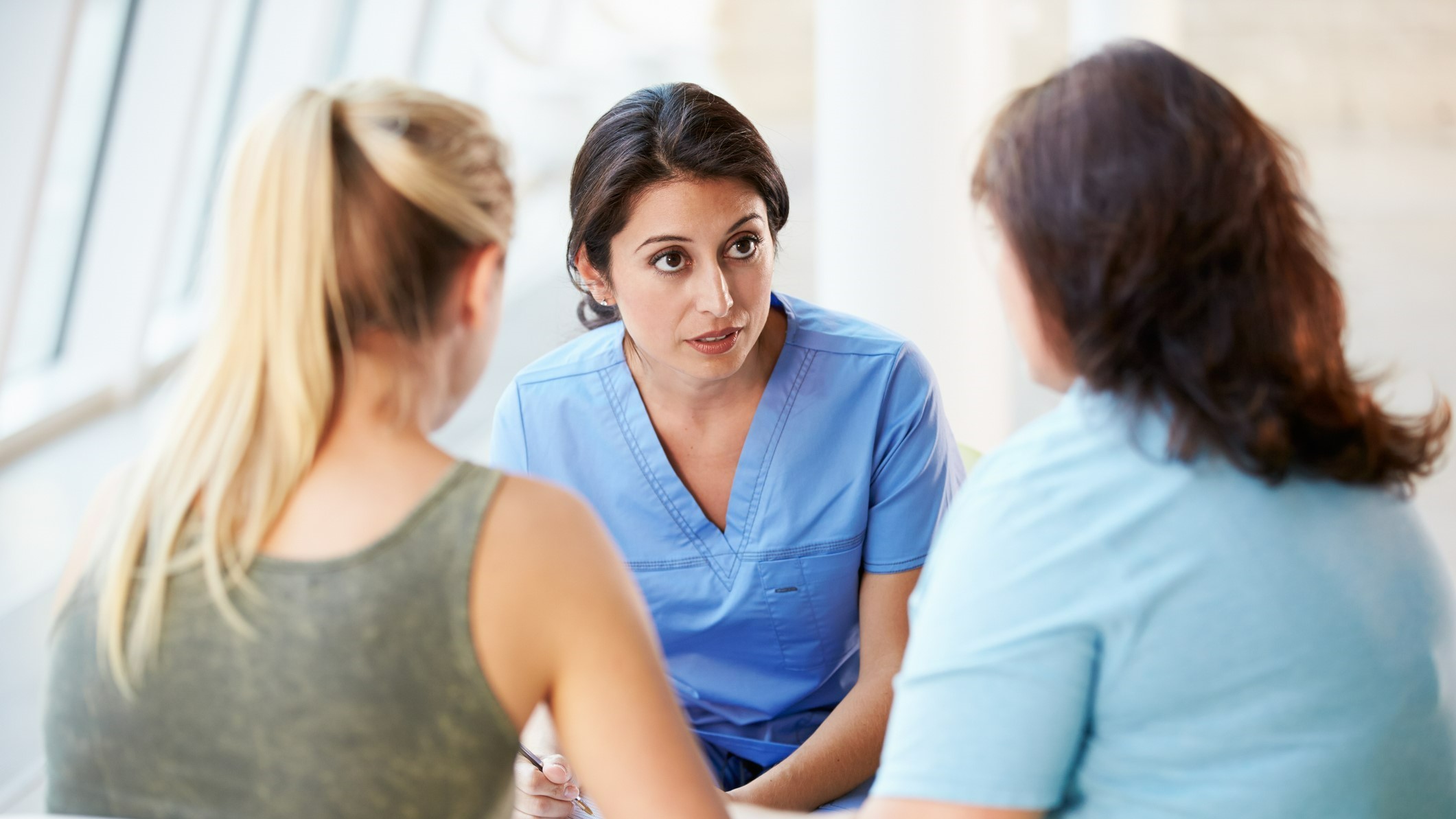 Parent and teen sitting down, speaking with a medical provider