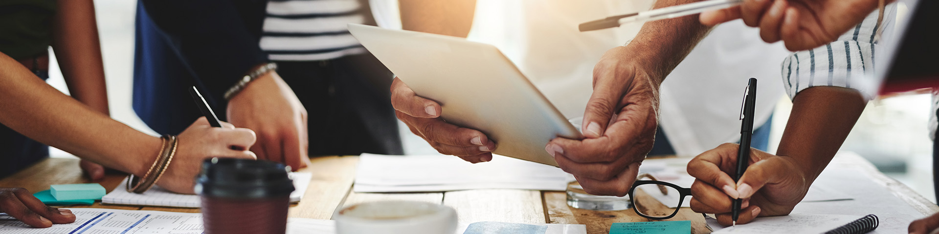 Multiple people working around a table together.