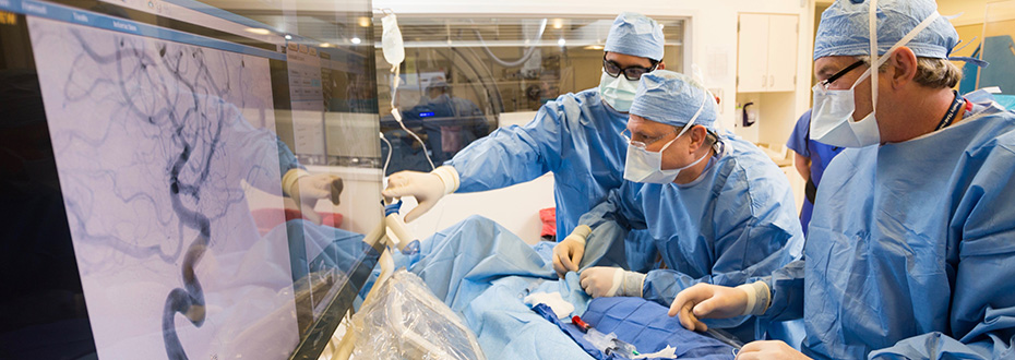 OHSU doctors in scrubs and masks performing a procedure and using advanced imaging technology equipment