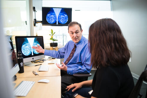 Dr. Mueller, OHSU plastic surgeon, discussing a breast scan image in office.