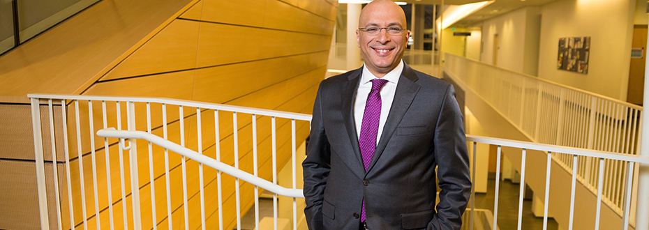 A portrait photo Dr. Ahmed Raslan, a neurosurgeon at OHSU in a grey suit and purple tie