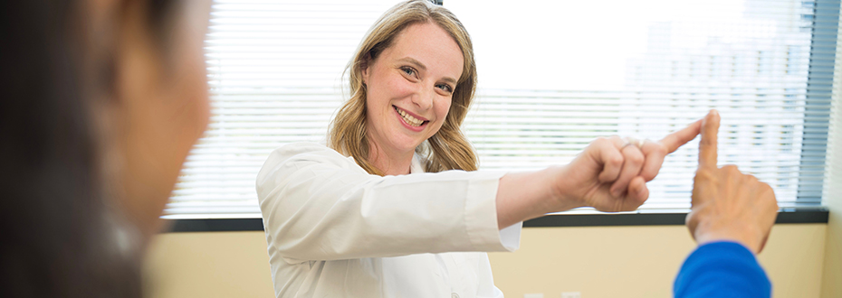 Shannon Anderson, a physician assistant at the OHSU Parkinson Center touching fingers with a patient