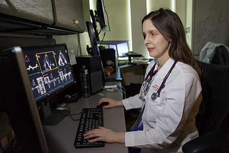 Dr. Abigail Khan looks at heart scan images on her computer.