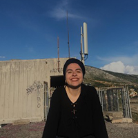 A woman stands in front of a building