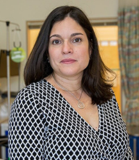 A portrait of Dr. Eneida Nemechek with a neutral expression, wearing a geographic print.