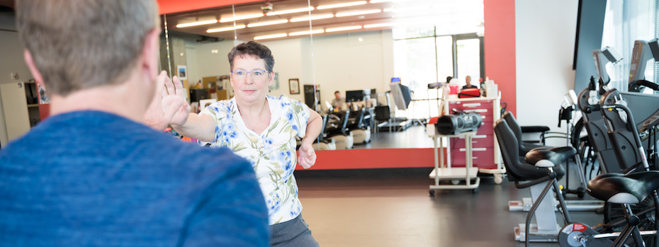 A physical and occupational therapist at OHSU shows another person how to do an exercise at an OHSU rehabilitation facility.