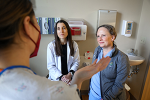 OHSU researchers speak to a maternity patient in a hospital gown.