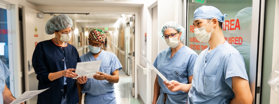Four members of OHSU’s Fetal Care team compare notes in a hallway.