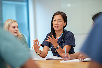 OHSU School of Nursing students sit around a table in a classroom, collaborating during a learning session.