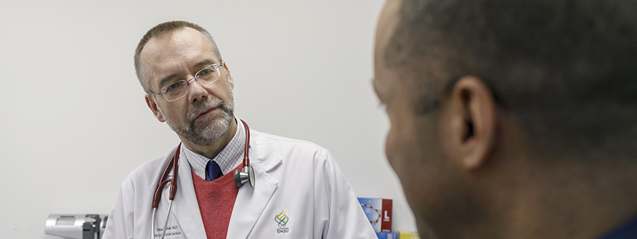 An OHSU doctor listens to a patient in an exam room.