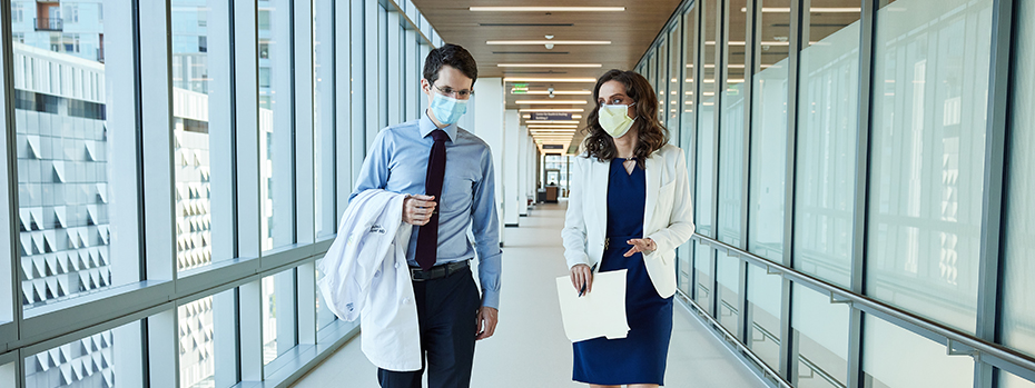 Two OHSU doctors walk through a hallway.