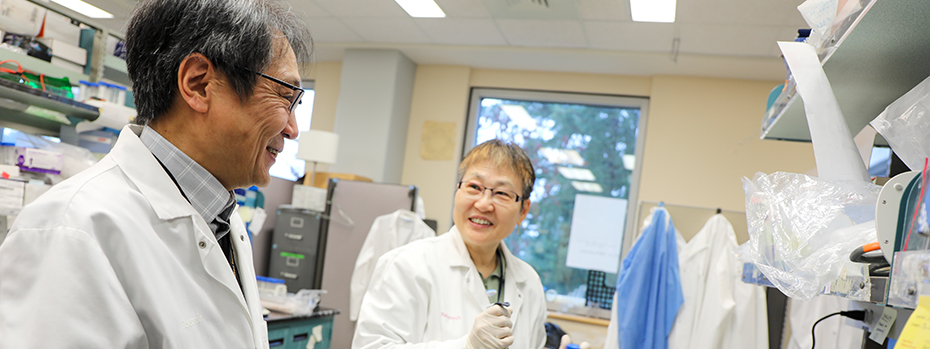 Researchers wearing lab coats working in a lab at OHSU