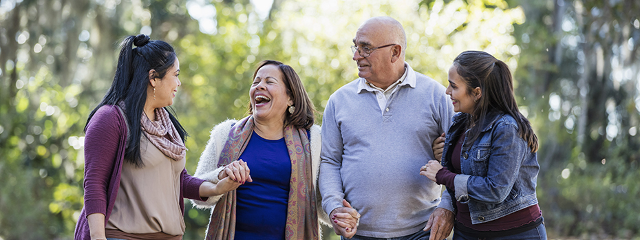 An older couple and two young adults enjoy a moment together in the woods.