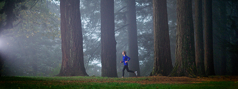 A jogger running through a foggy forest