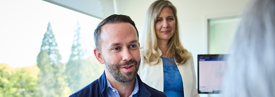 Dr. Fields talks with a patient. Dr. Sara Cichowski stands in the background.