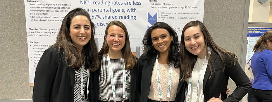 4 women in front of scholarship presentation folder