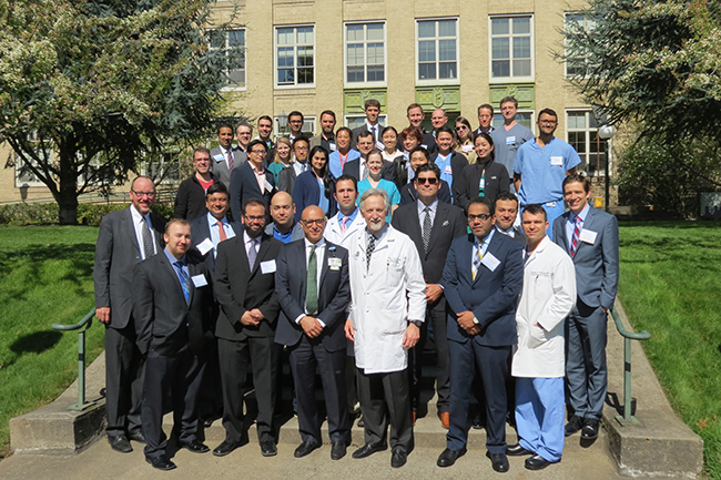 A group of over 30 doctors, trainers, residents and fellows standing outside an academic building at OHSU.