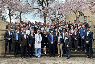 A group of approximately 80 doctors, trainers, residents and fellows standing on steps outside on OHSU campus in 2024.