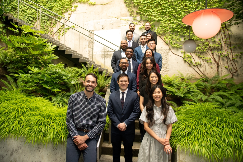 Large group stands on a staircase posing for a professional group photo.