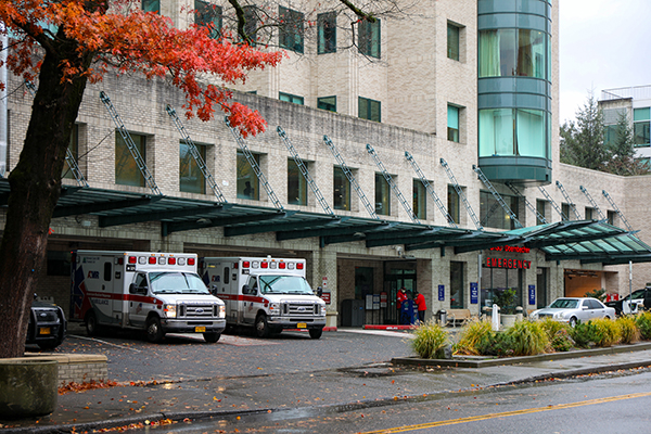 Two ambulances sit next to the entrance to the OHSU-Doernbecher Emergency Department.