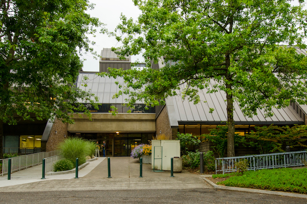 Building with sloped roof with trees in front of it